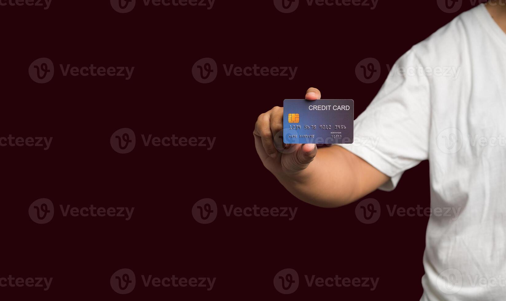 Close-up of hand holding a mockup credit card while standing on a red background photo