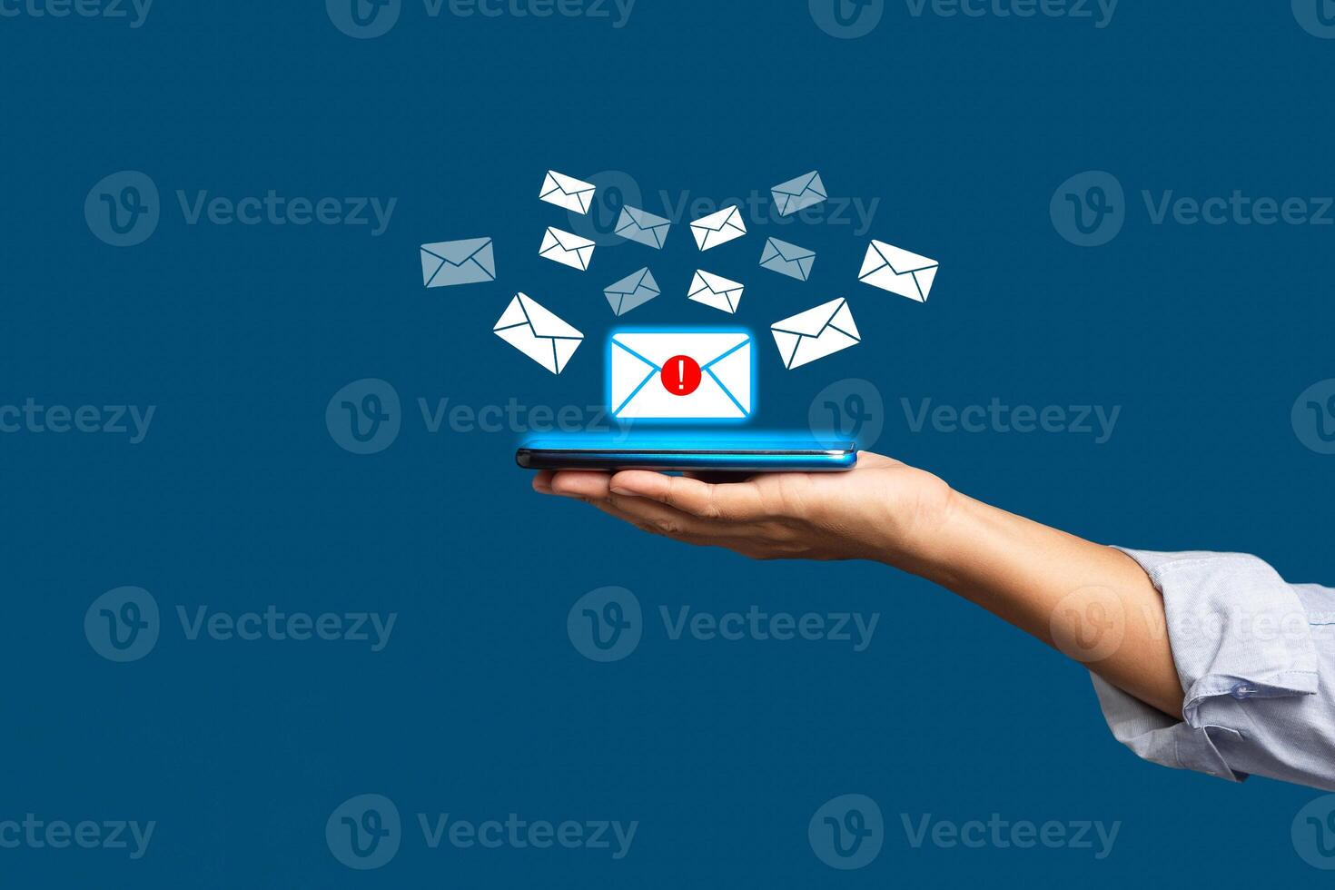 Email marketing concept. A smartphone on the palm with receives a new message with email icons on a virtual screen over a blue background photo