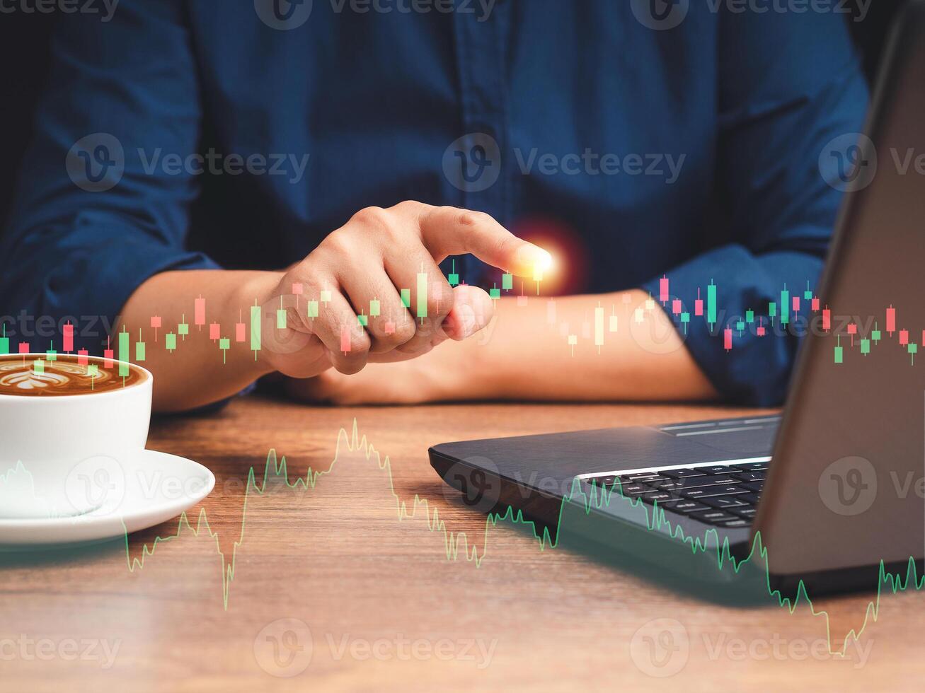 Businessman pointing on graph stock on virtual screen while sitting on the table in the office photo