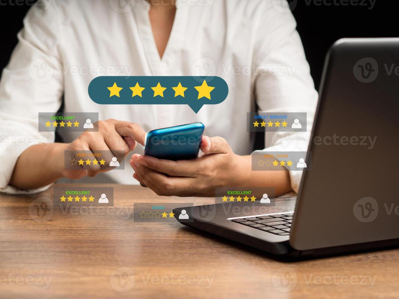 Close-up of hands woman using a smartphone gives the five-star icon a rating of very impressed for service while sitting in the office photo