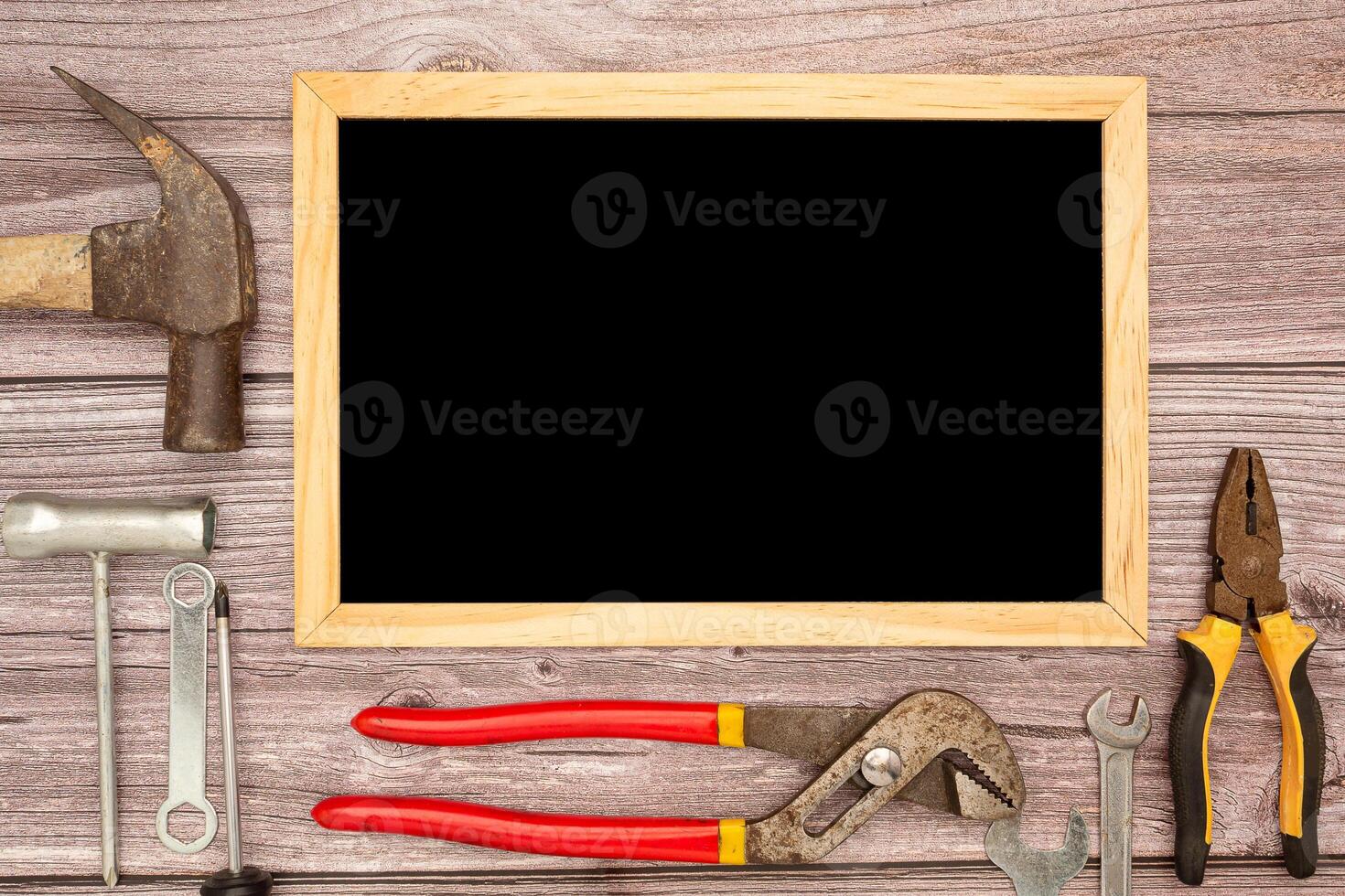 A blank mini chalkboard and construction tools on a wooden table photo