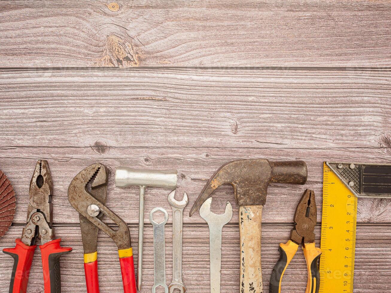 Construction tools, a hammer, screwdriver, screws, and pliers on a wooden table photo