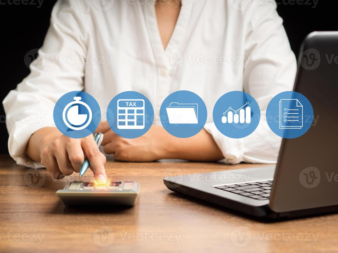 A businesswoman uses a calculator to calculate taxes while sitting in the office photo