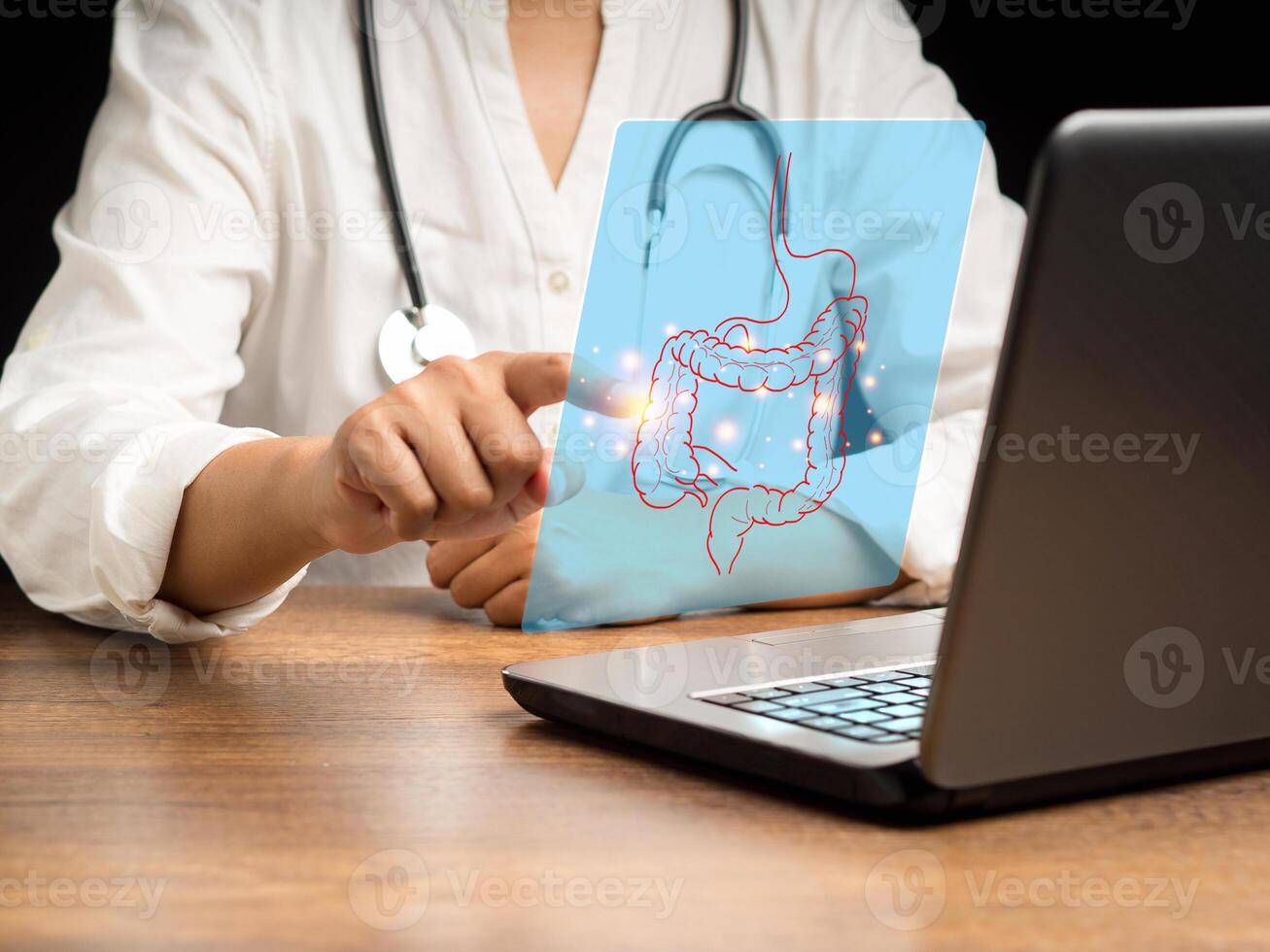 Hand of a doctor touching an image of a colon symbol on a virtual screen while sitting in the hospital photo