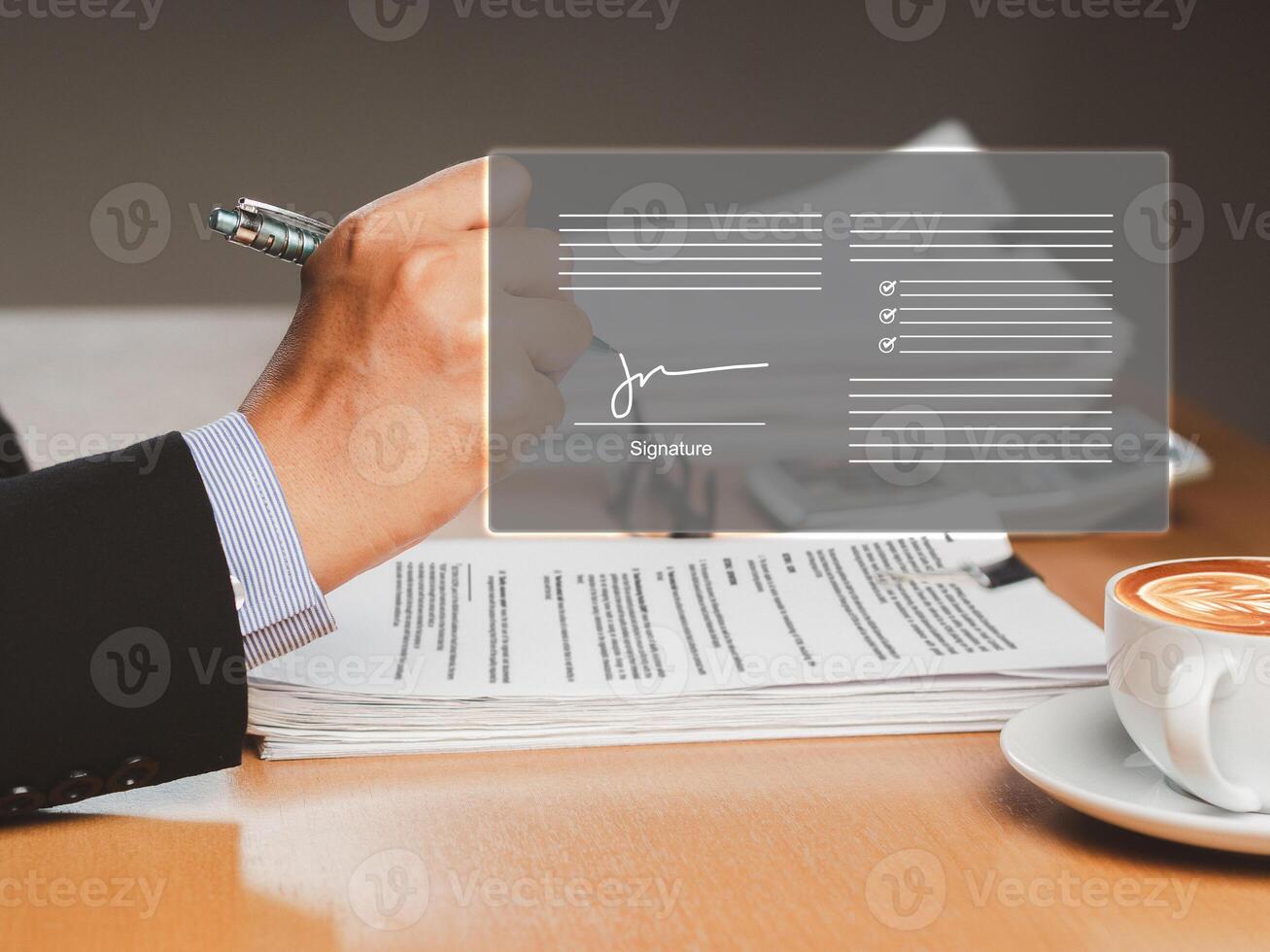 A businessman uses a pen to sign electronic documents on a virtual screen while sitting in the office photo