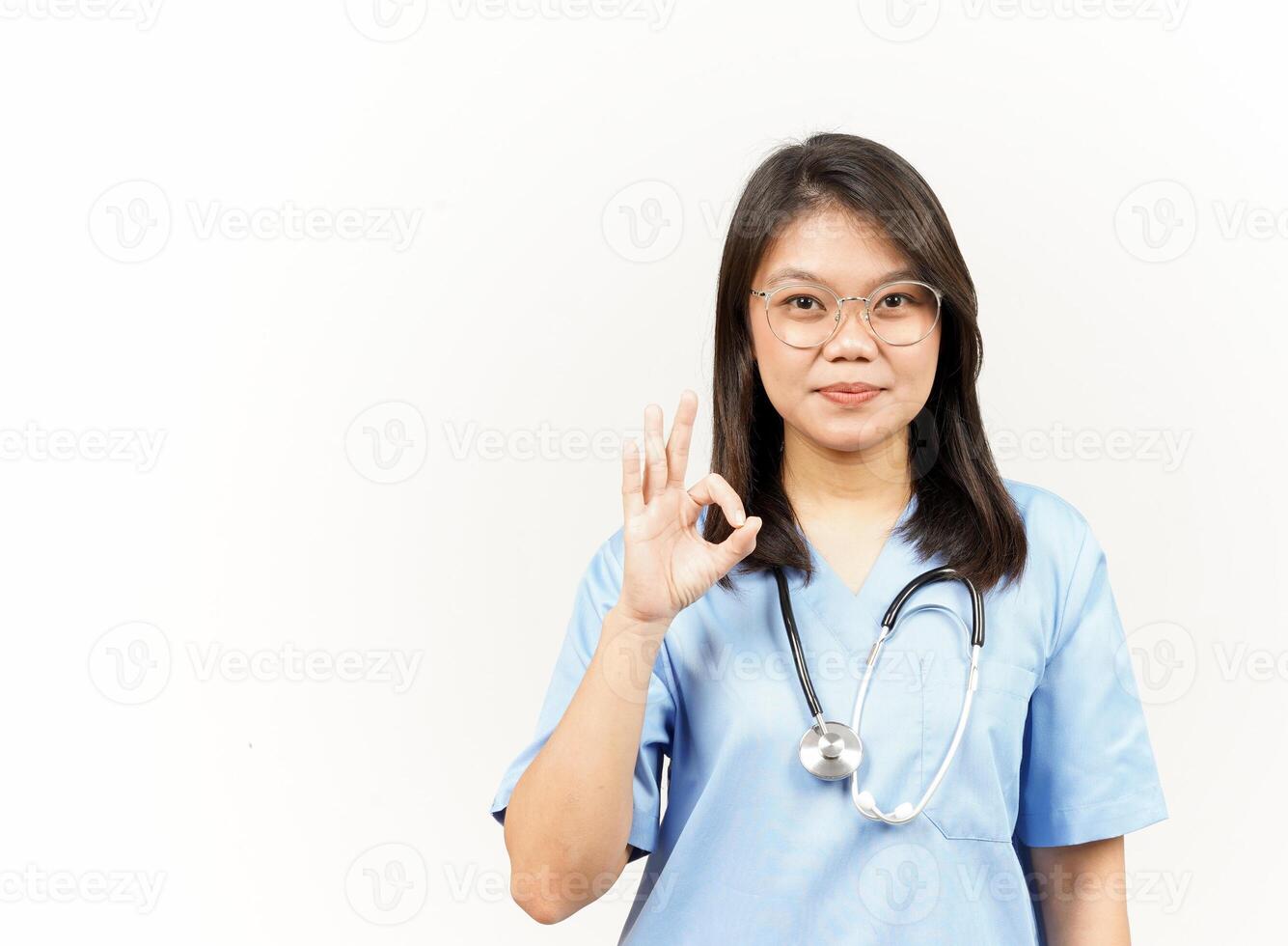 Showing OK Sign Of Asian Young Doctor Isolated On White Background photo