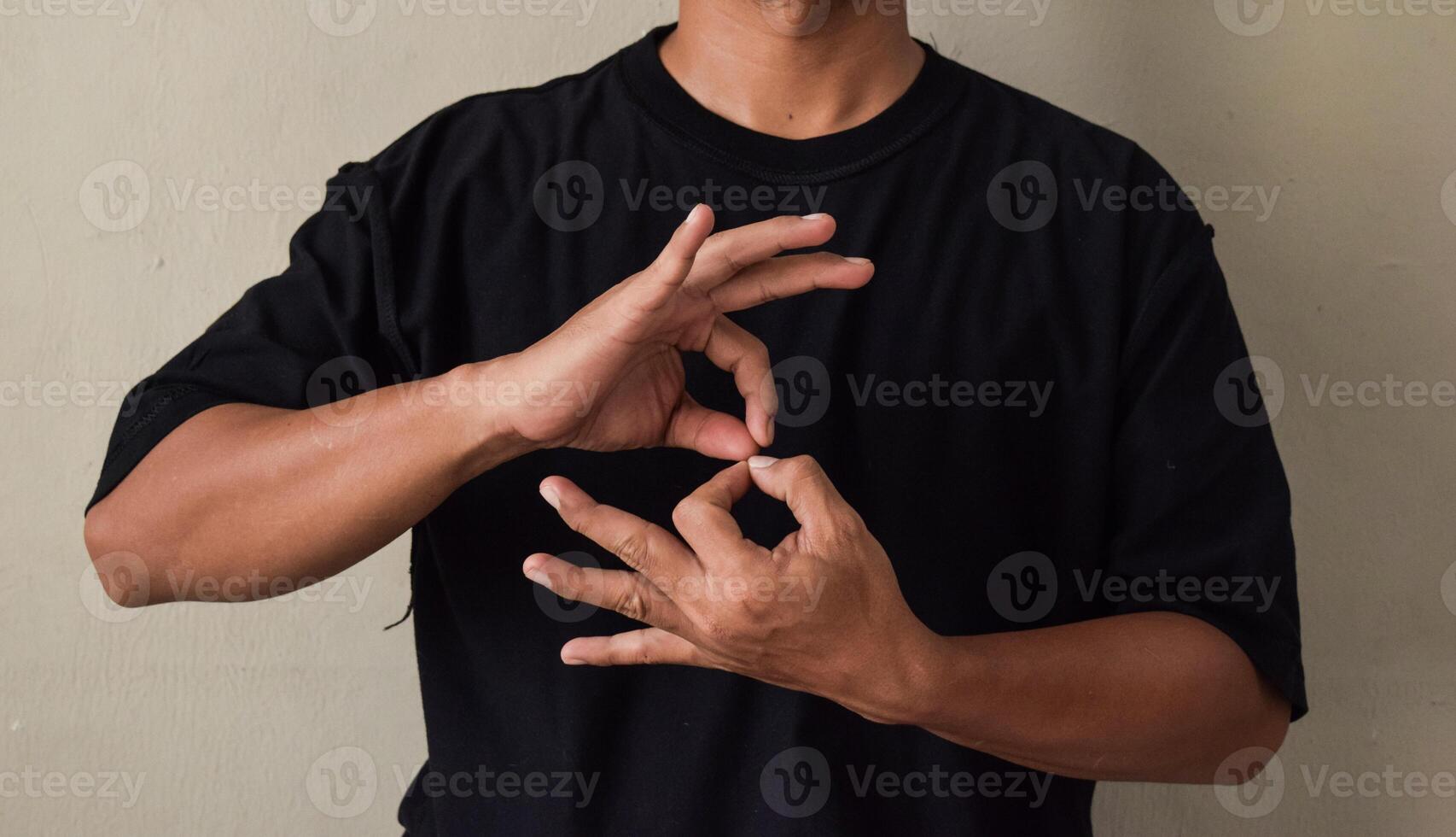 Young man learns sign language to talk, hand gestures of people with hearing impairment photo