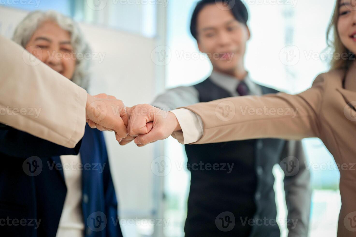 A close-up of diverse businesspeople fist bumping after a productive meeting in a modern office. photo