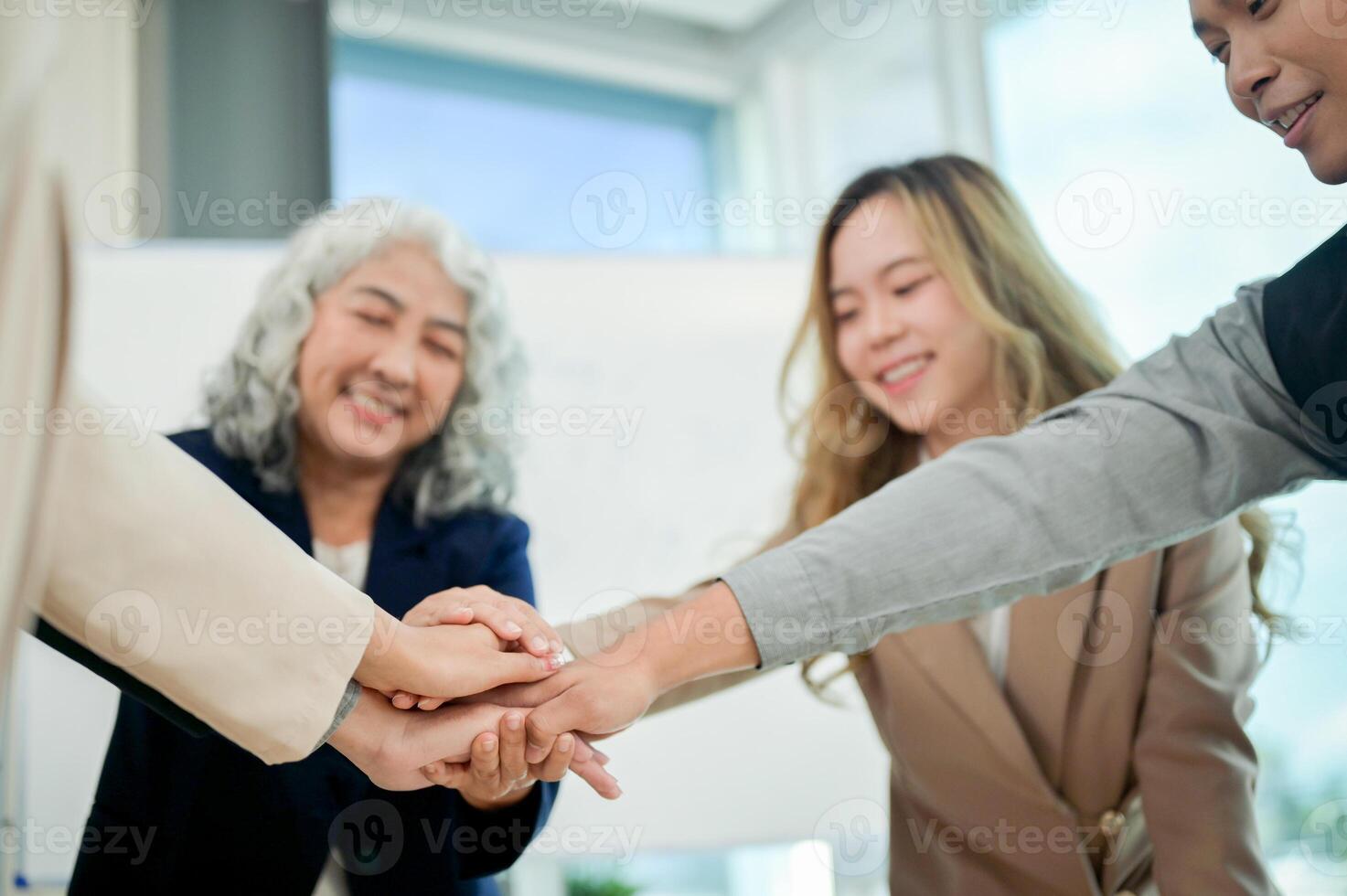 A close-up of businesspeople's hands coming together in a teamwork gesture, celebrating success. photo