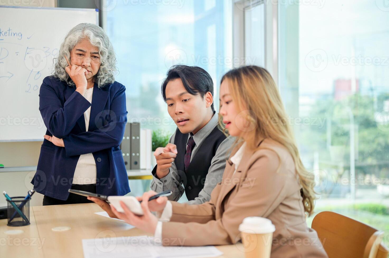 Diverse Asian businesspeople working together in a modern office, all focused on the discussion. photo