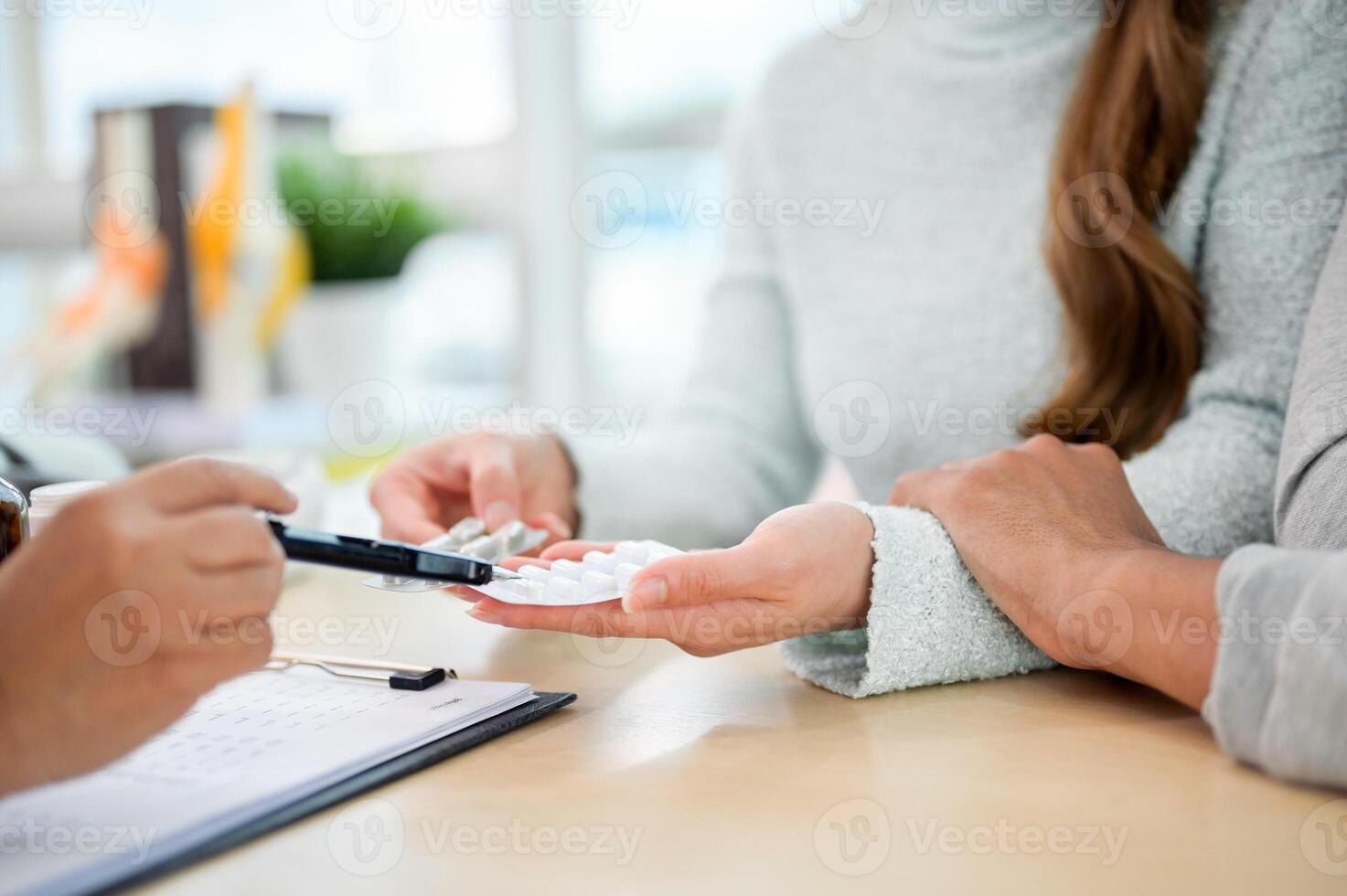 A close-up of a doctor explaining the instructions for the medication to a patient during the visit. photo