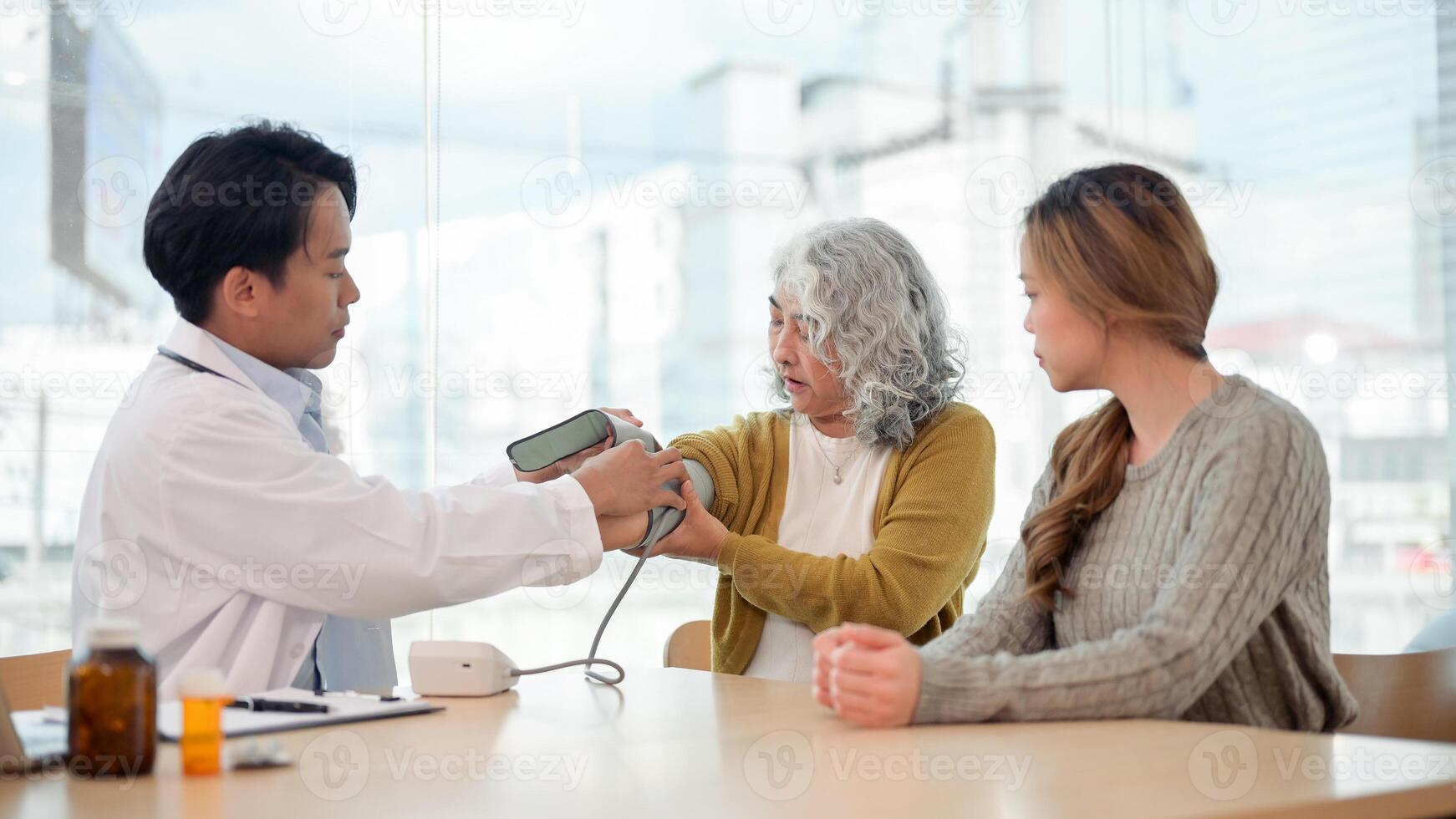 A retired grandmother having her blood pressure measured by a monitor while visiting the doctor. photo