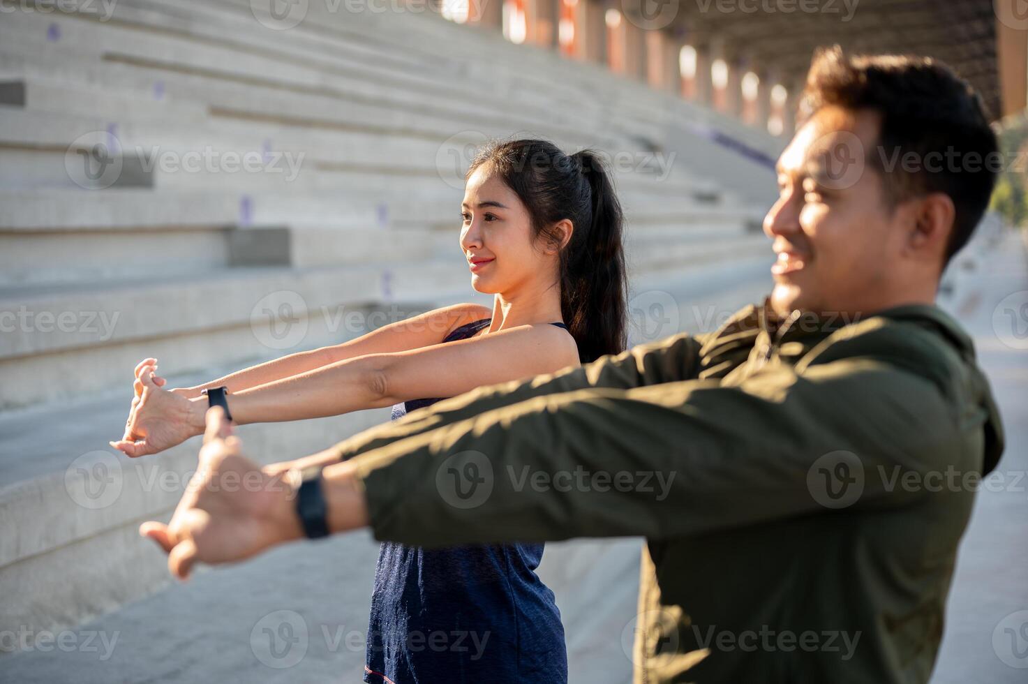 A charming Asian female in sportswear stretches her body before running, exercising with her friend. photo