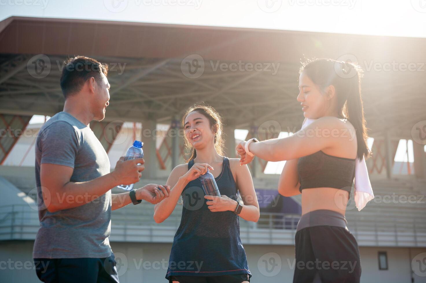 A group of athlete runners resting on a running track after training at a stadium on a sunny day. photo