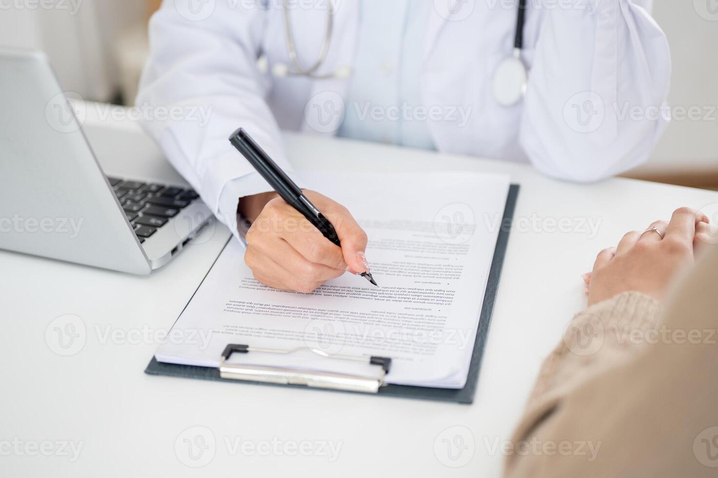 A close-up of a doctor filling out a medical form while examining a patient. photo