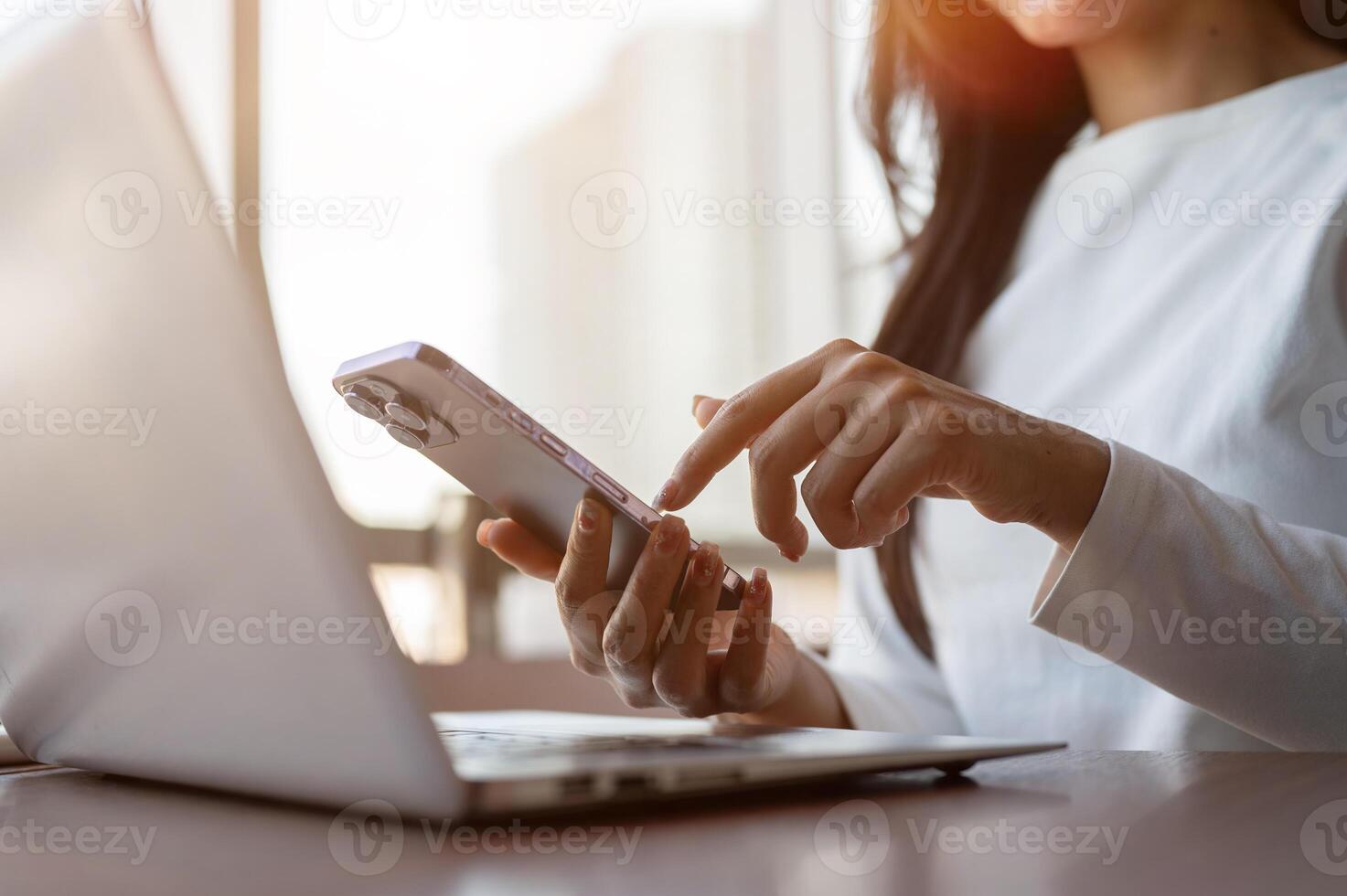 A close-up of a businesswoman touching her smartphone screen, using her smartphone while working. photo