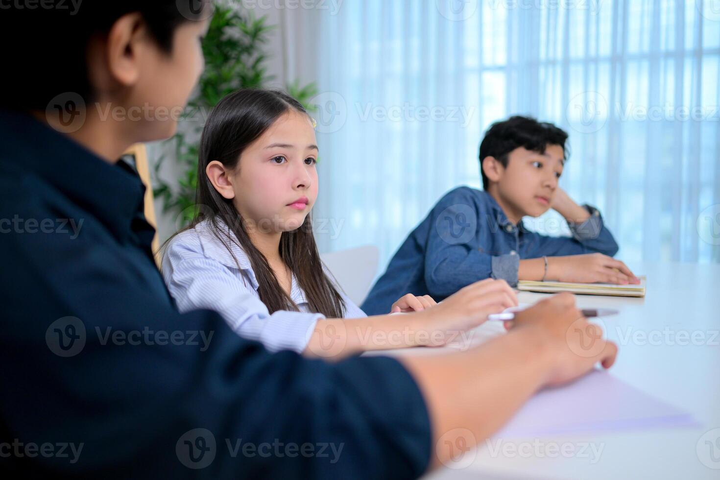 Small class, Teacher and pupils in the home classroom, reviewing lessons and offering homework advice photo