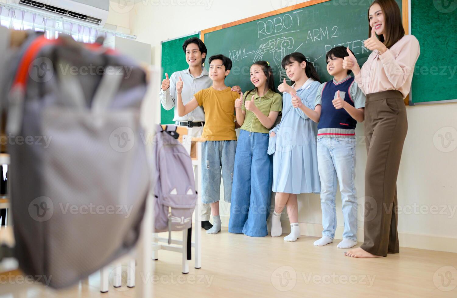 Portrait of a teacher and kids in a classroom where children have pleasure learning photo