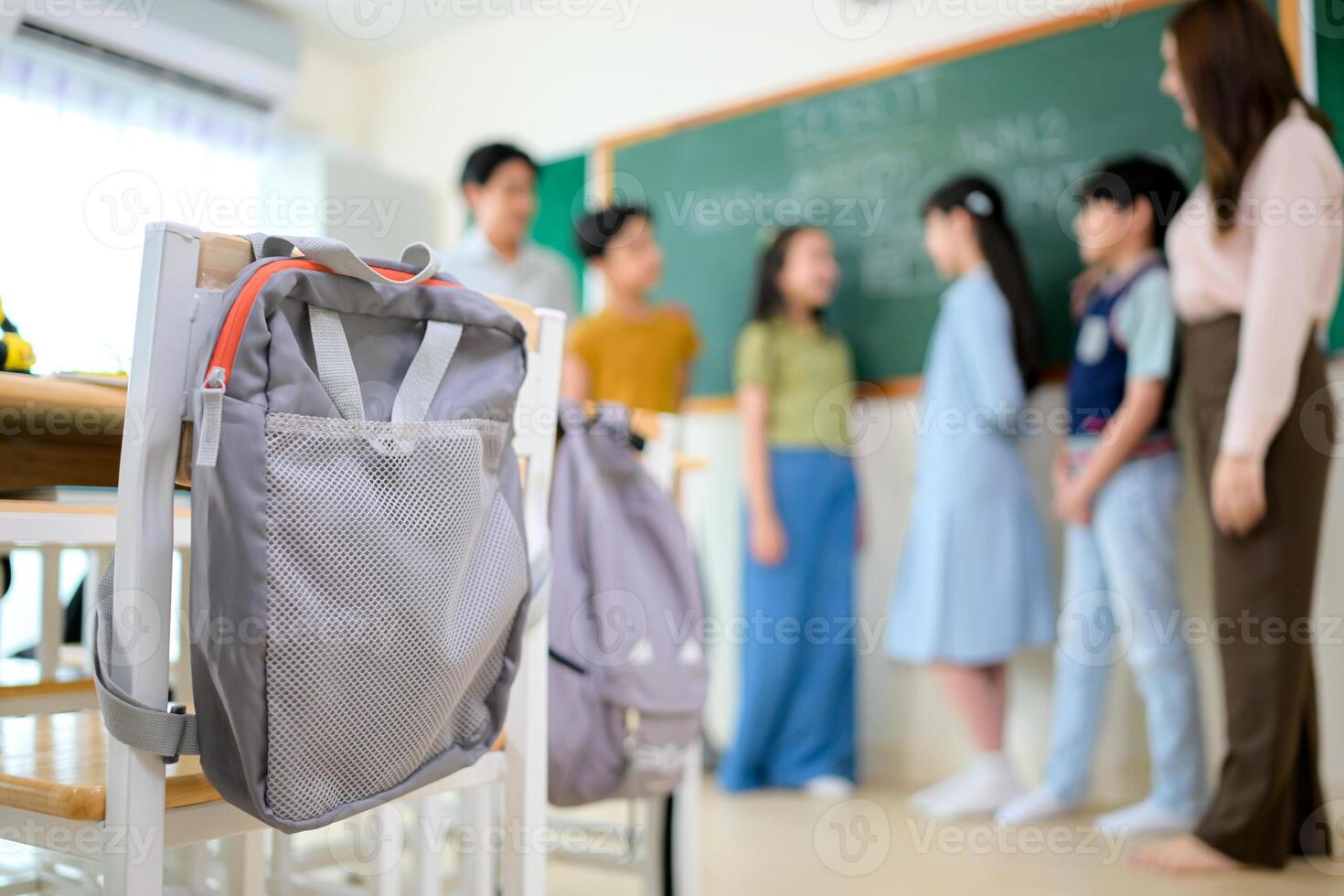Portrait of a teacher and kids in a classroom where children have pleasure learning photo