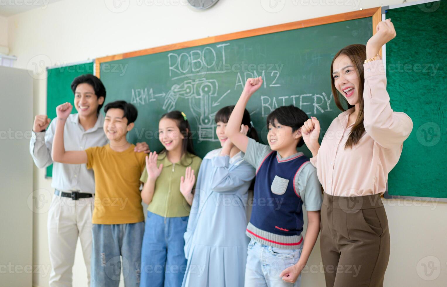 Portrait of a teacher and kids in a classroom where children have pleasure learning photo