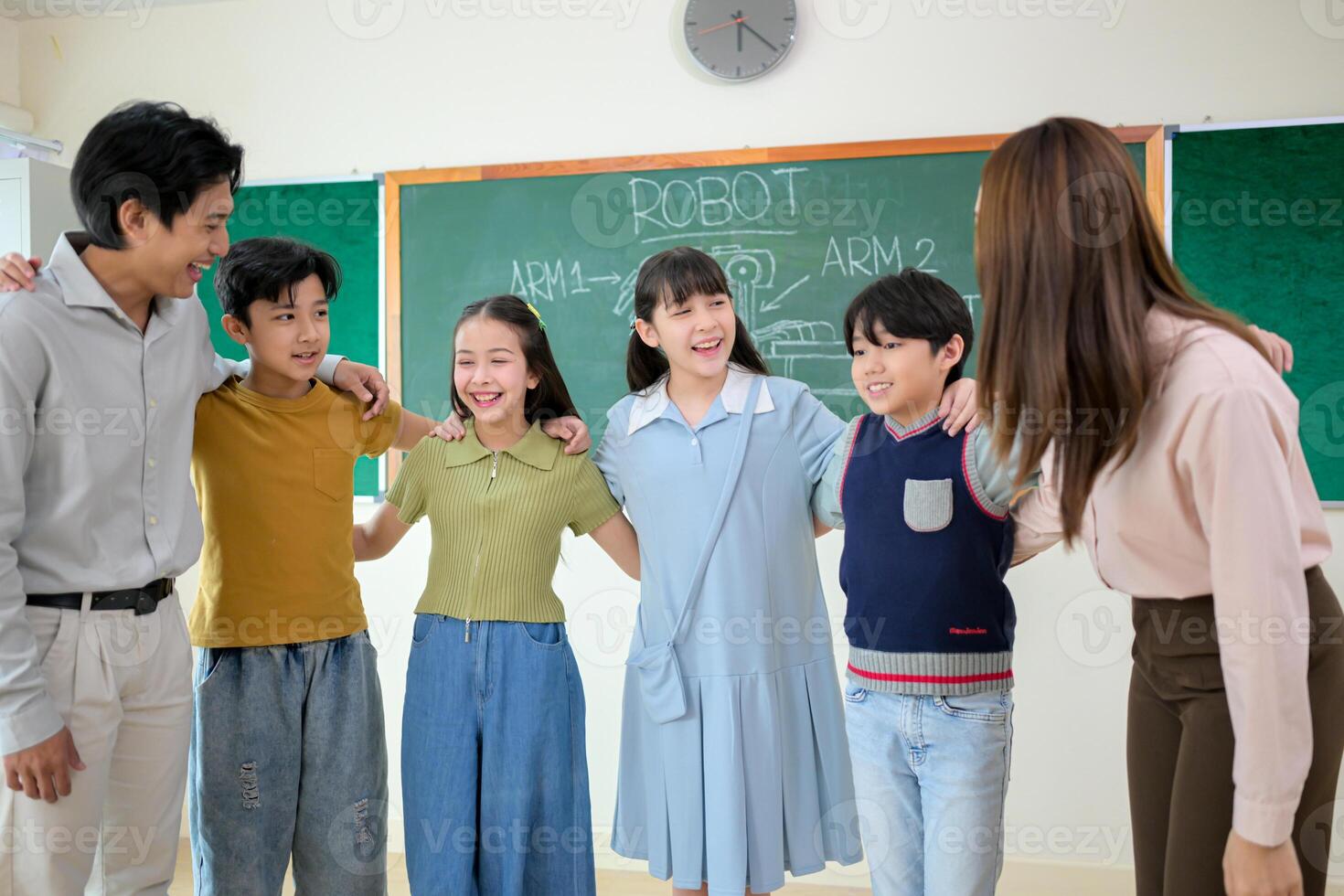 Portrait of a teacher and kids in a classroom where children have pleasure learning photo