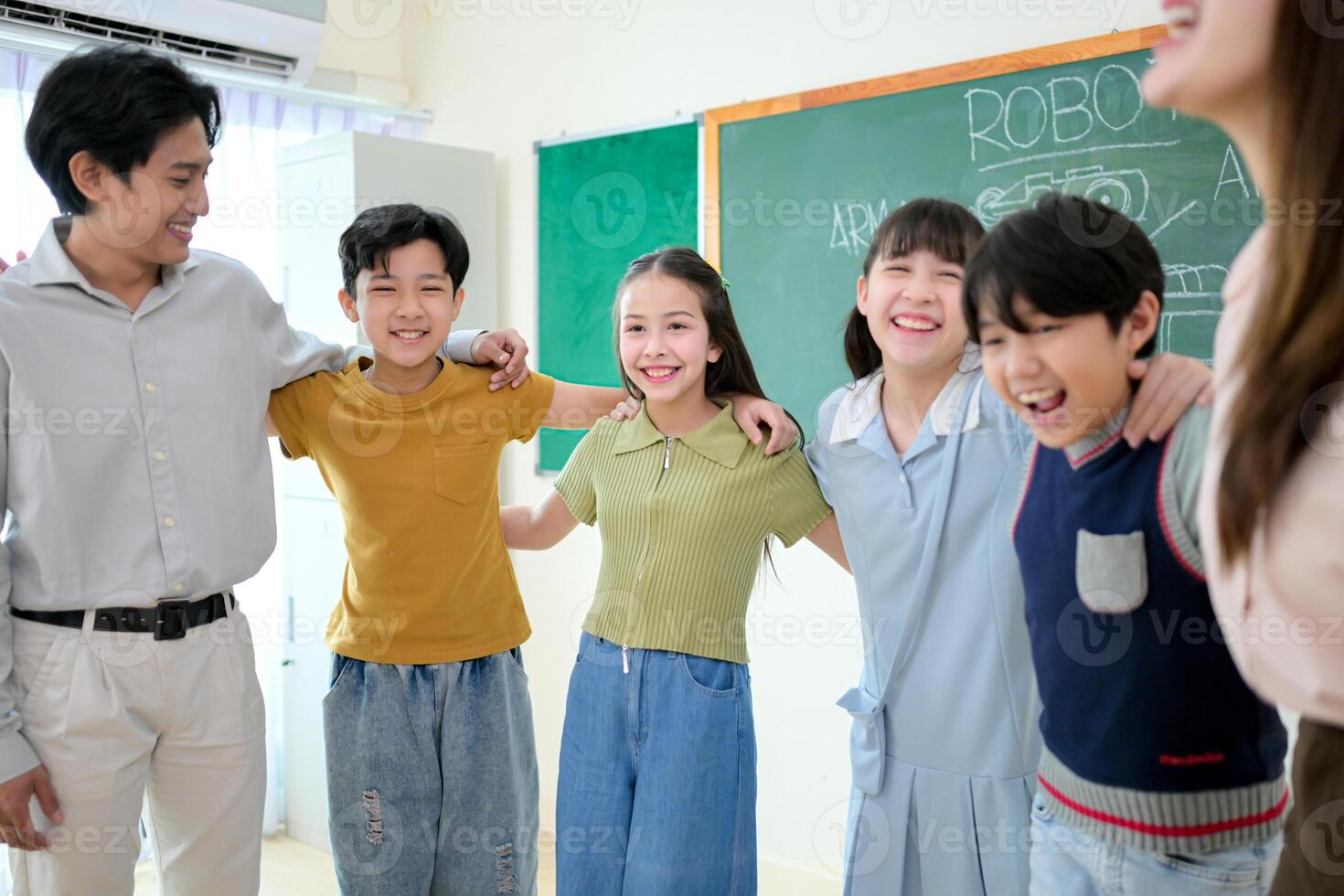 Portrait of a teacher and kids in a classroom where children have pleasure learning photo