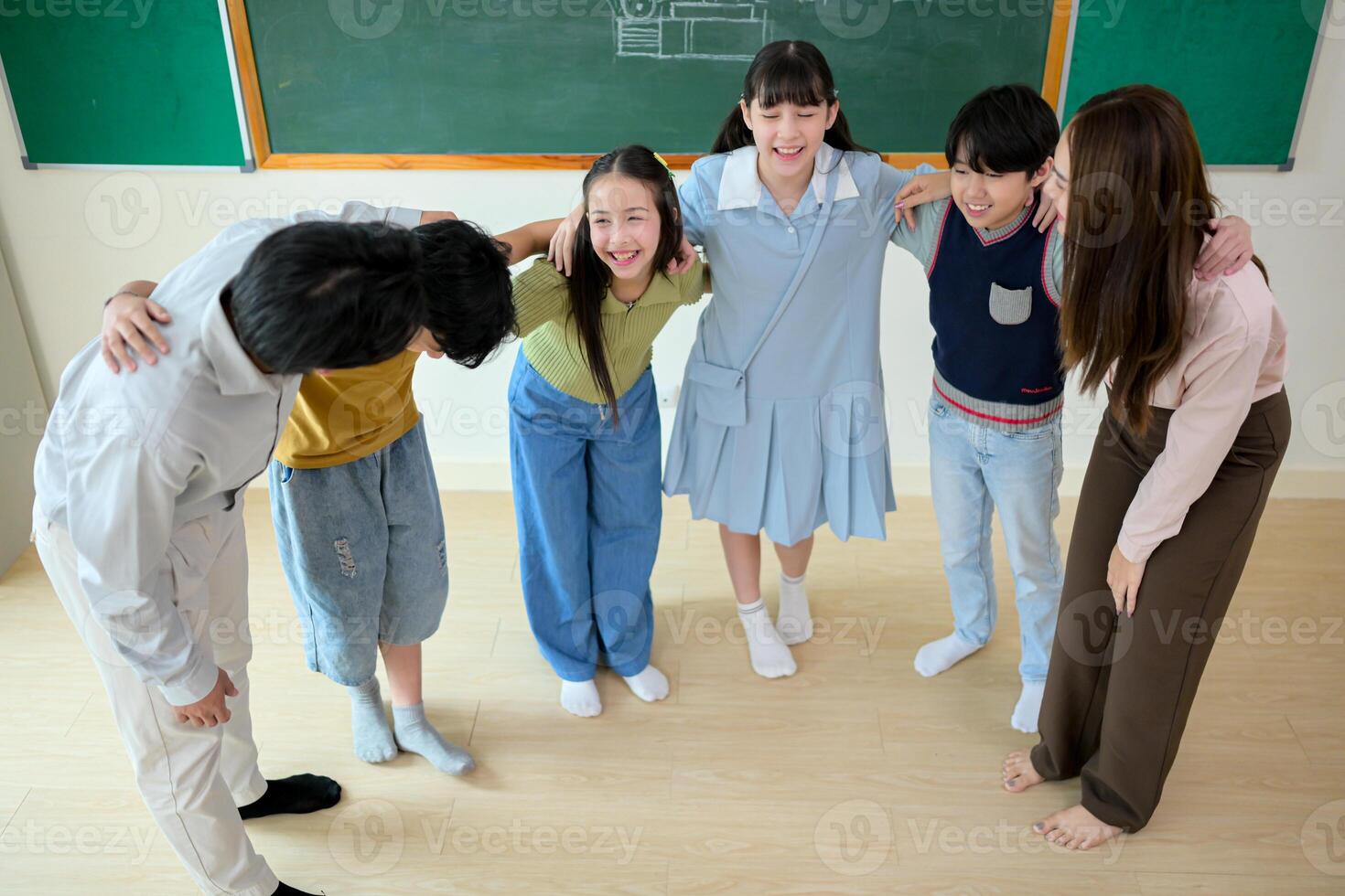 Portrait of a teacher and kids in a classroom where children have pleasure learning photo
