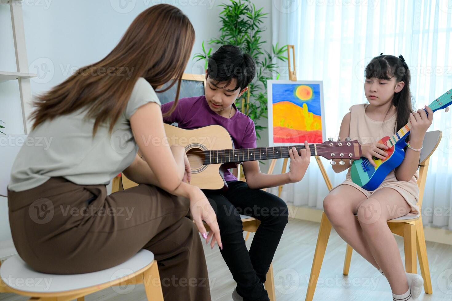 Ukelele and Guitar class, Teacher and students in music classroom photo