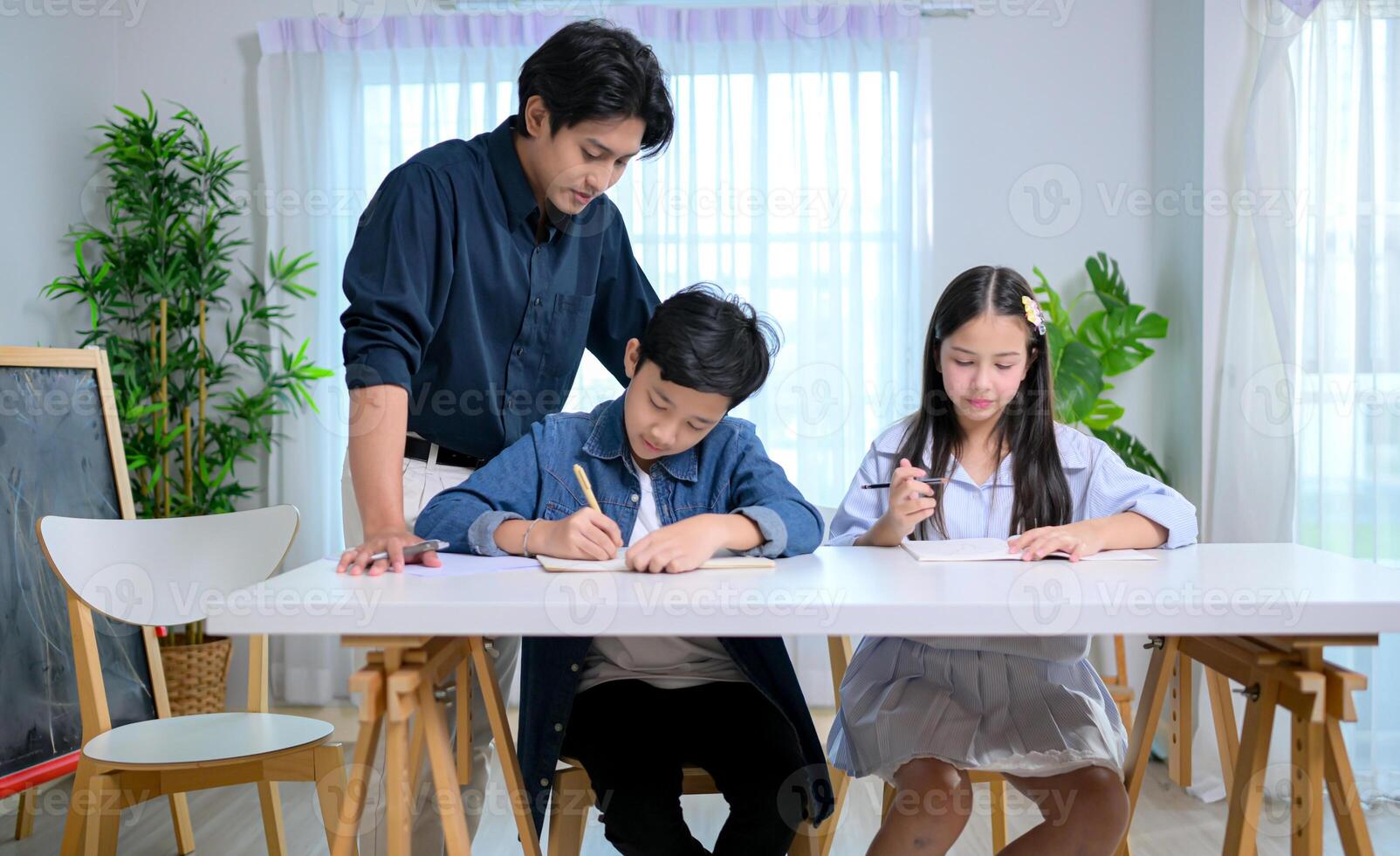Small class, Teacher and pupils in the home classroom, reviewing lessons and offering homework advice photo