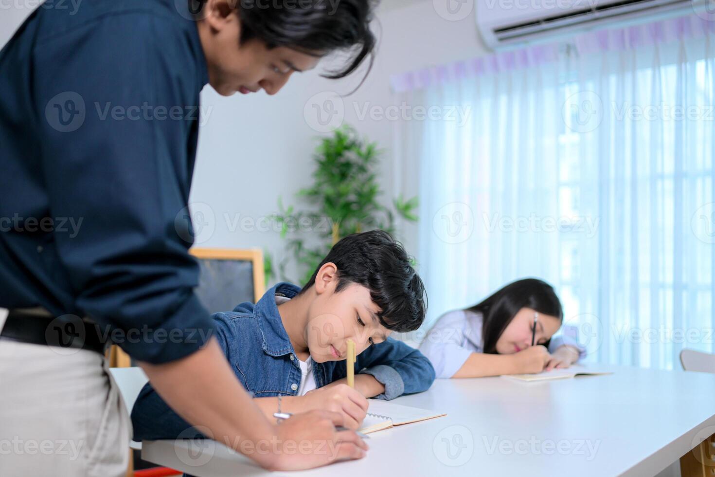 Small class, Teacher and pupils in the home classroom, reviewing lessons and offering homework advice photo