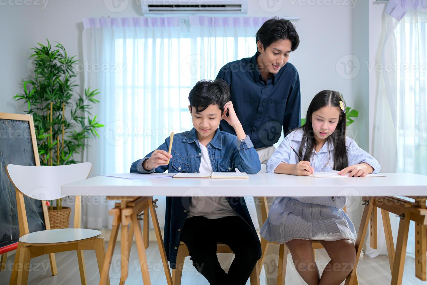 Small class, Teacher and pupils in the home classroom, reviewing lessons and offering homework advice photo
