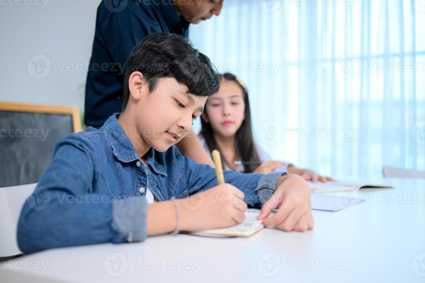 Small class, Teacher and pupils in the home classroom, reviewing lessons and offering homework advice photo