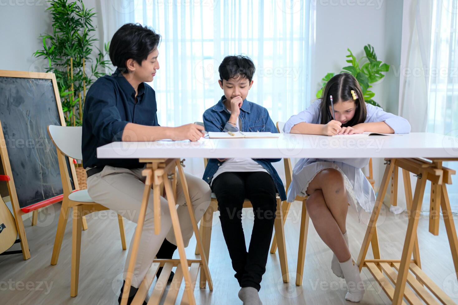 Small class, Teacher and pupils in the home classroom, reviewing lessons and offering homework advice photo