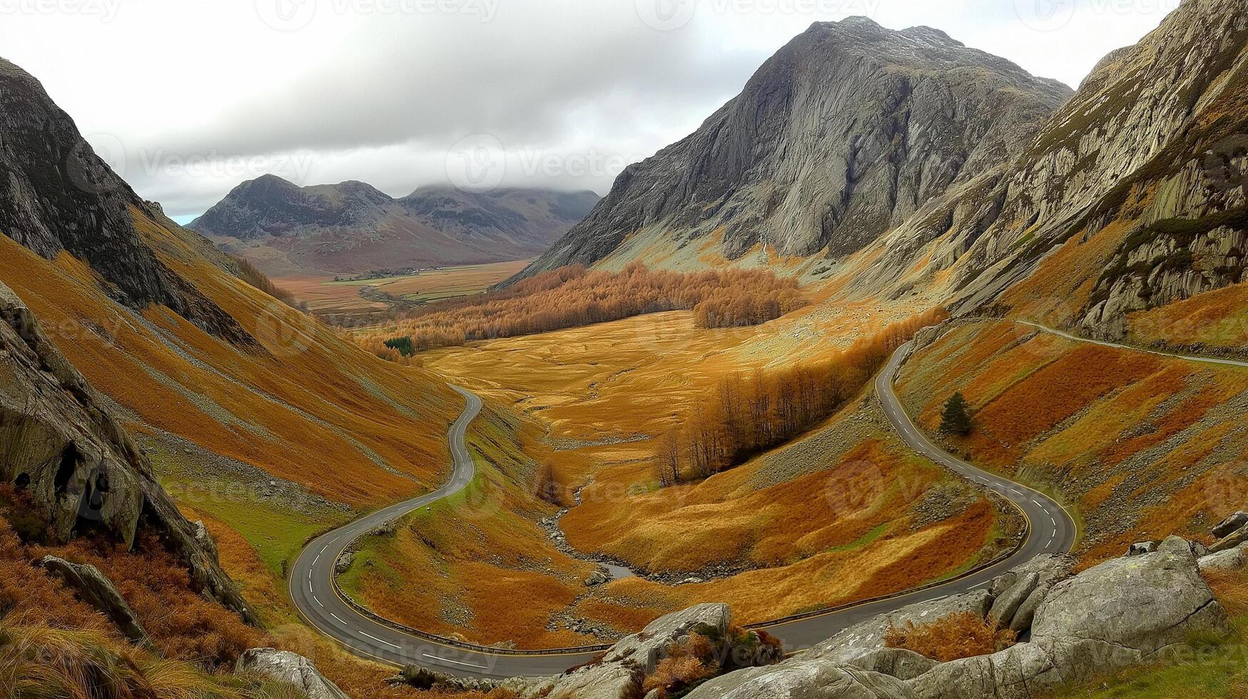 Winding road through autumnal mountain valley photo