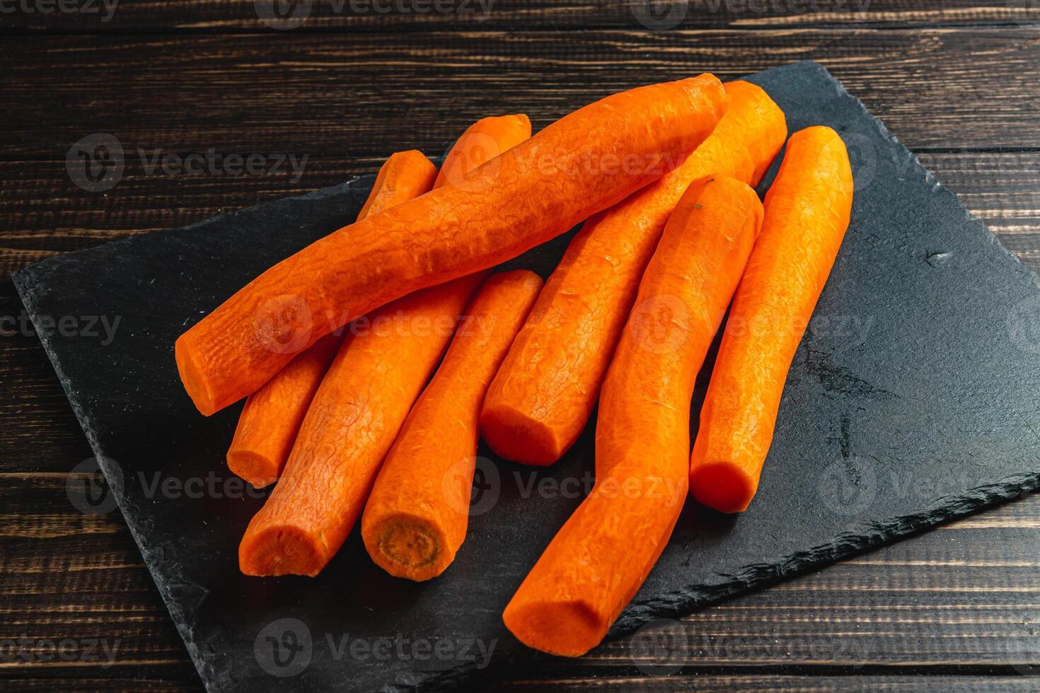 Washed fresh carrots on a stone board on a wooden table photo