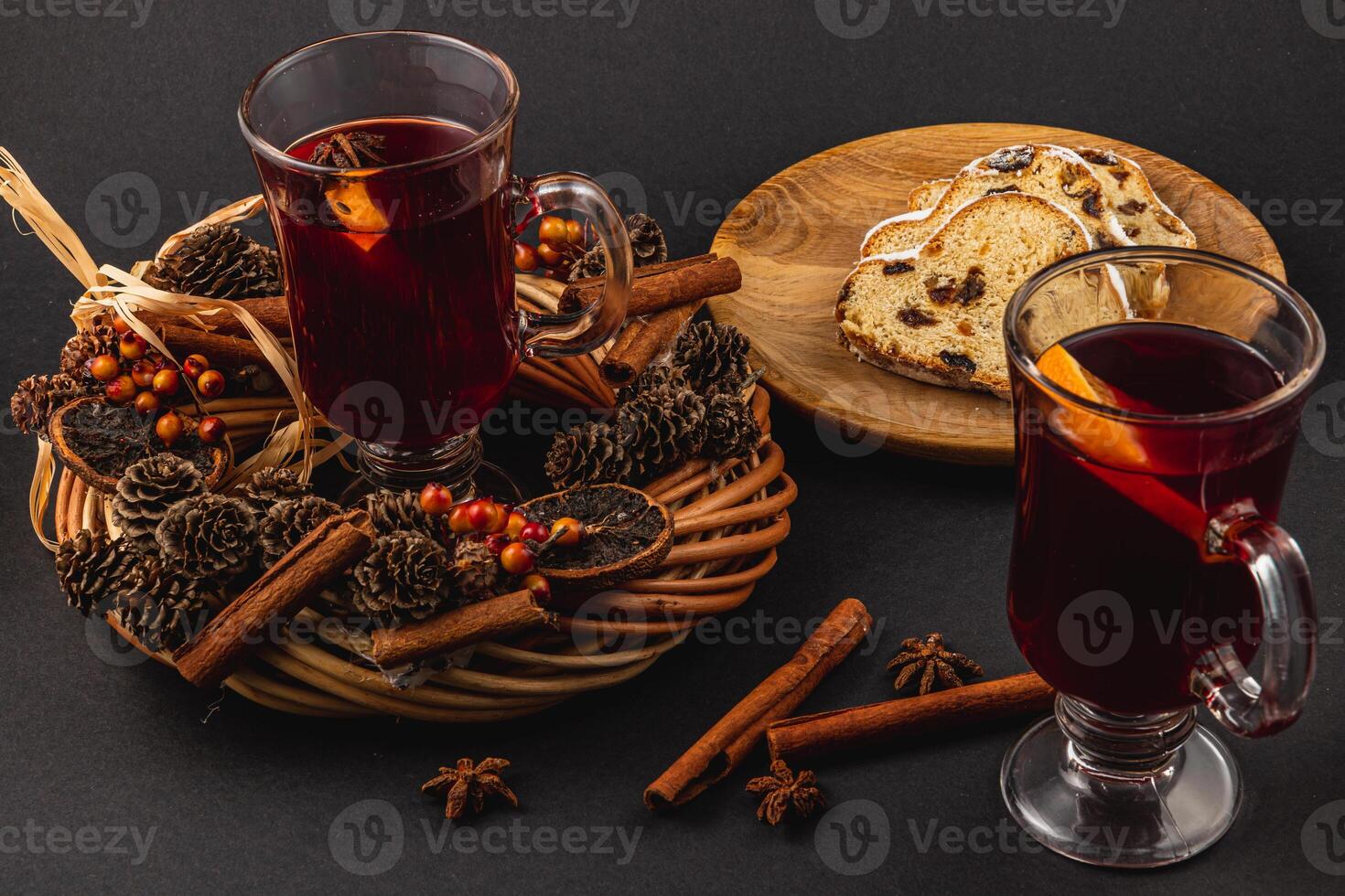 aromatic mulled wine with fresh stollen on a wooden plate on a black background photo