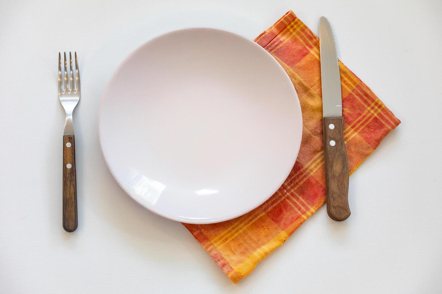 Empty plate top view with metal cutlery next to it photo