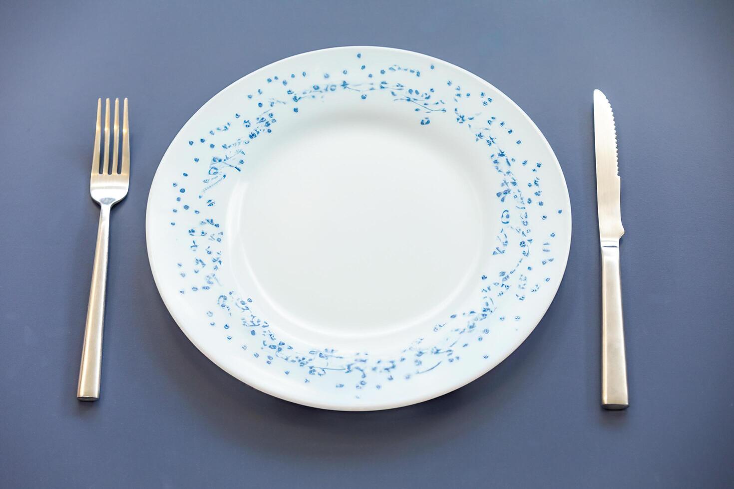 Empty plate top view with metal cutlery next to it photo