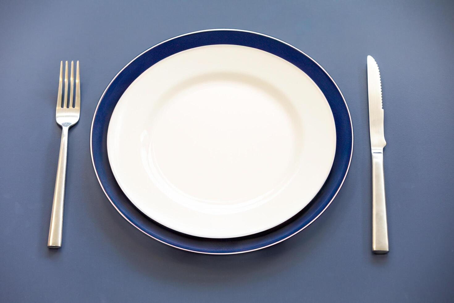 Empty plate top view with metal cutlery next to it photo