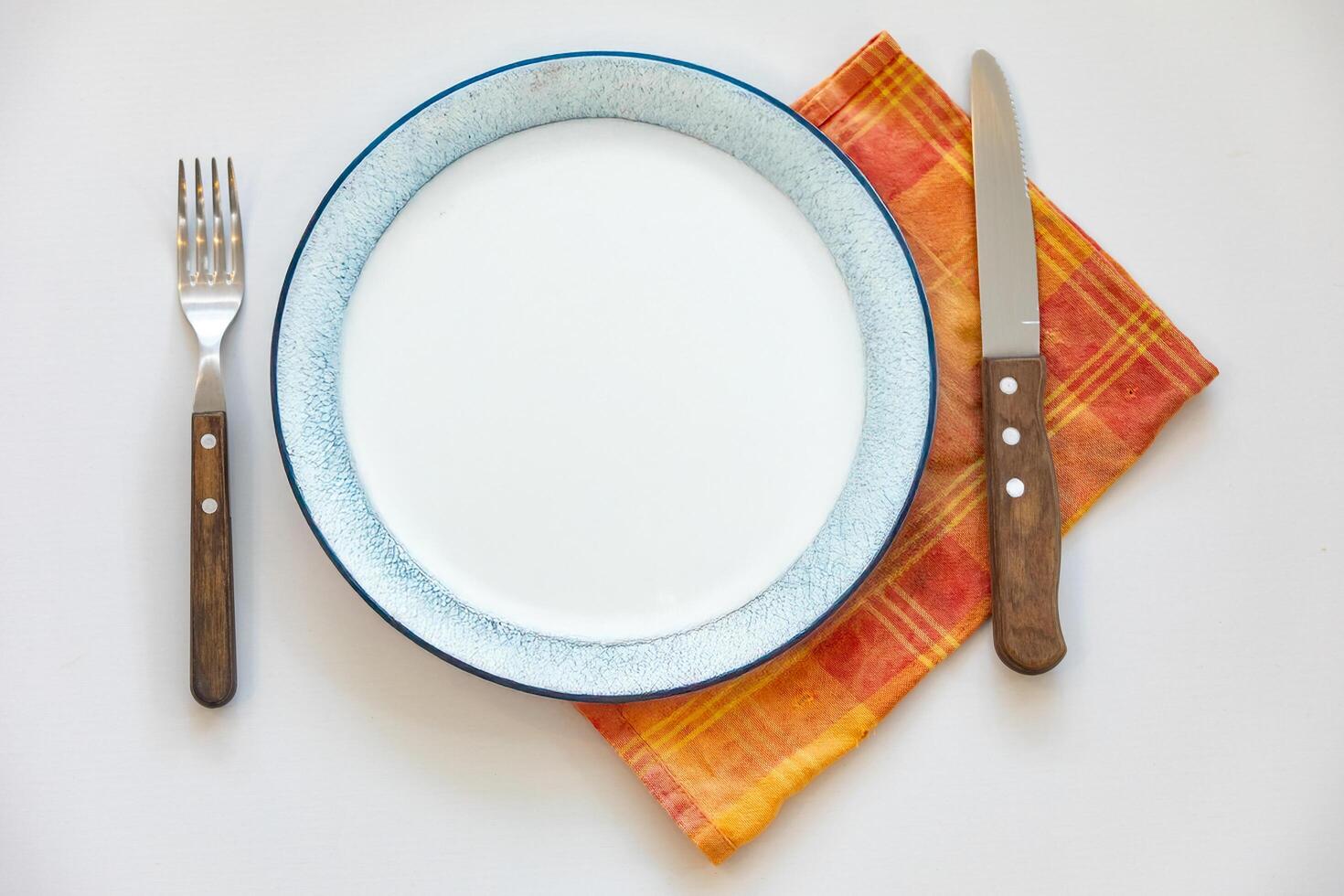 Empty plate top view with metal cutlery next to it photo
