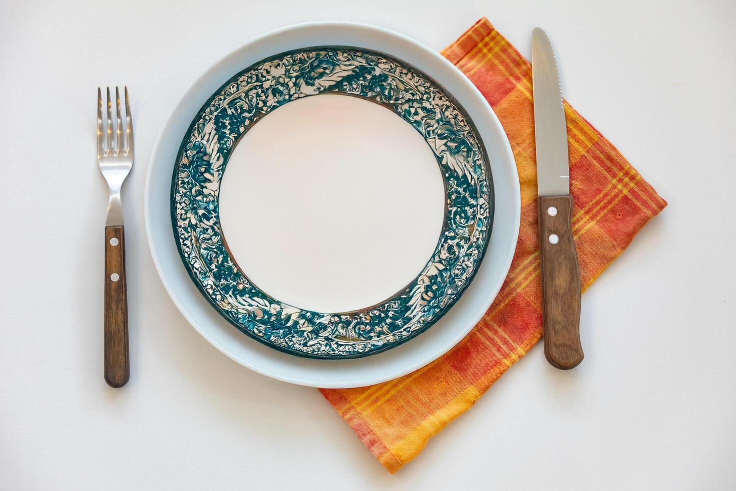 Empty plate top view with metal cutlery next to it photo