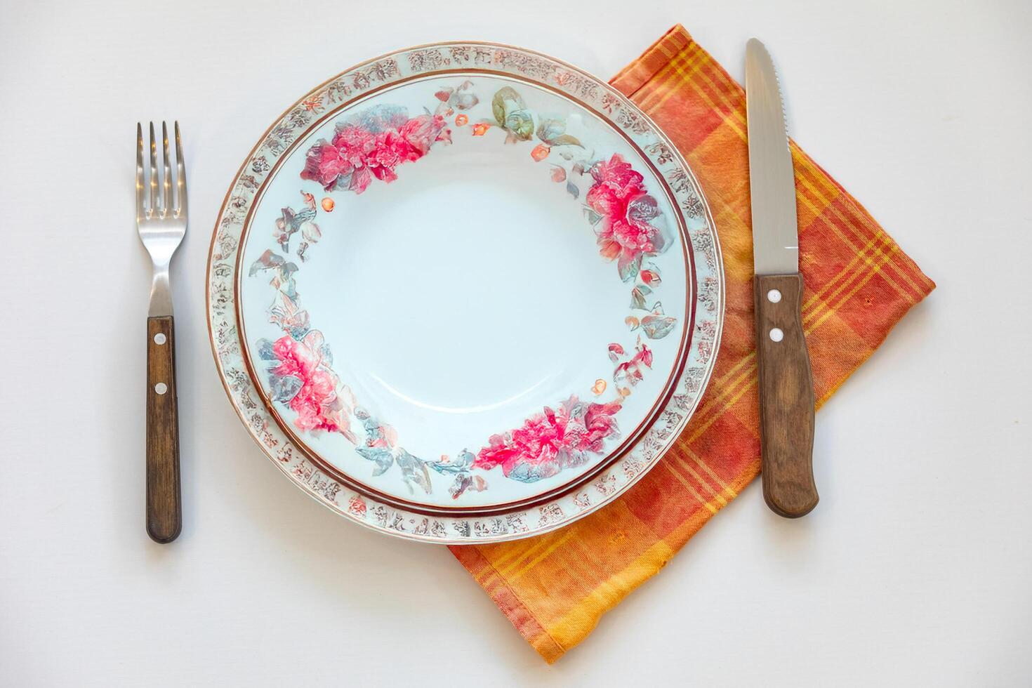 Empty plate top view with metal cutlery next to it photo