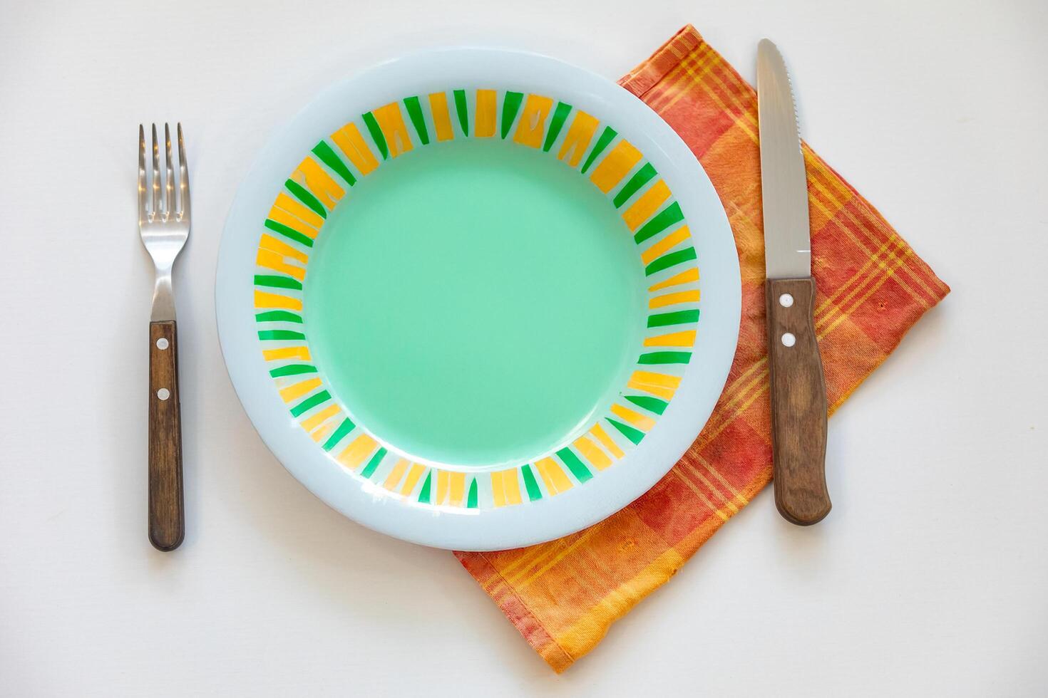 Empty plate top view with metal cutlery next to it photo