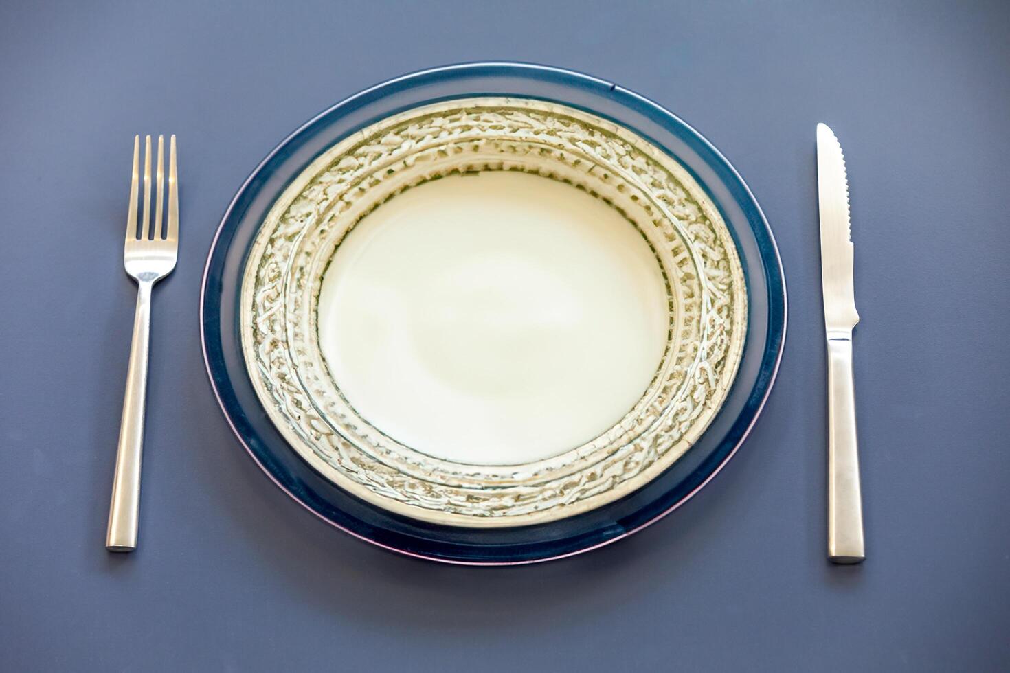 Empty plate top view with metal cutlery next to it photo