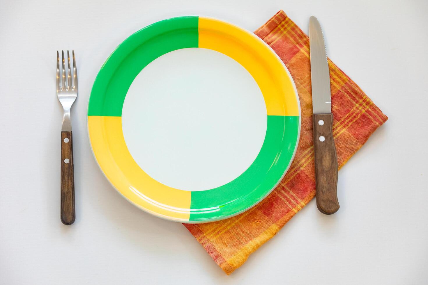 Empty plate top view with metal cutlery next to it photo