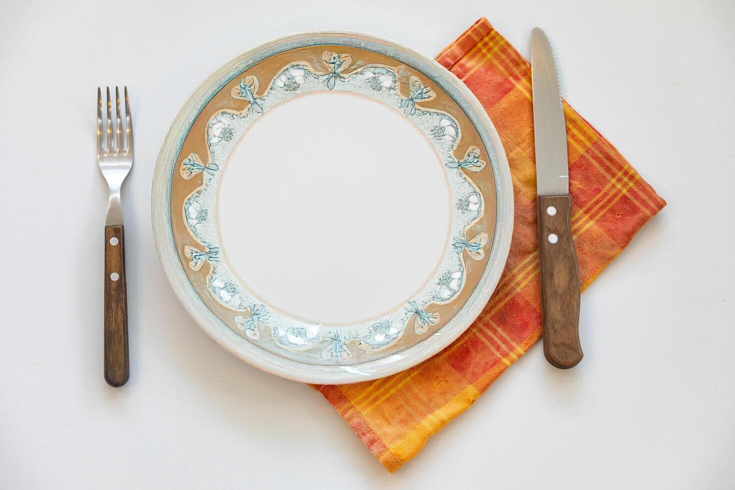 Empty plate top view with metal cutlery next to it photo