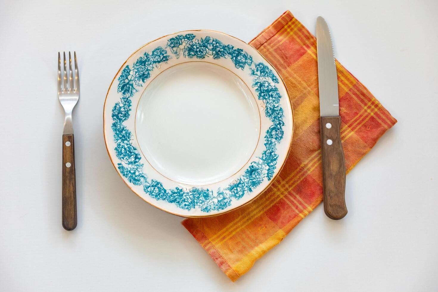 Empty plate top view with metal cutlery next to it photo