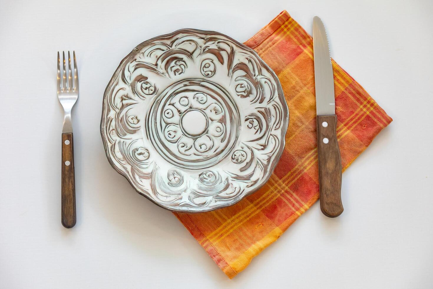 Empty plate top view with metal cutlery next to it photo