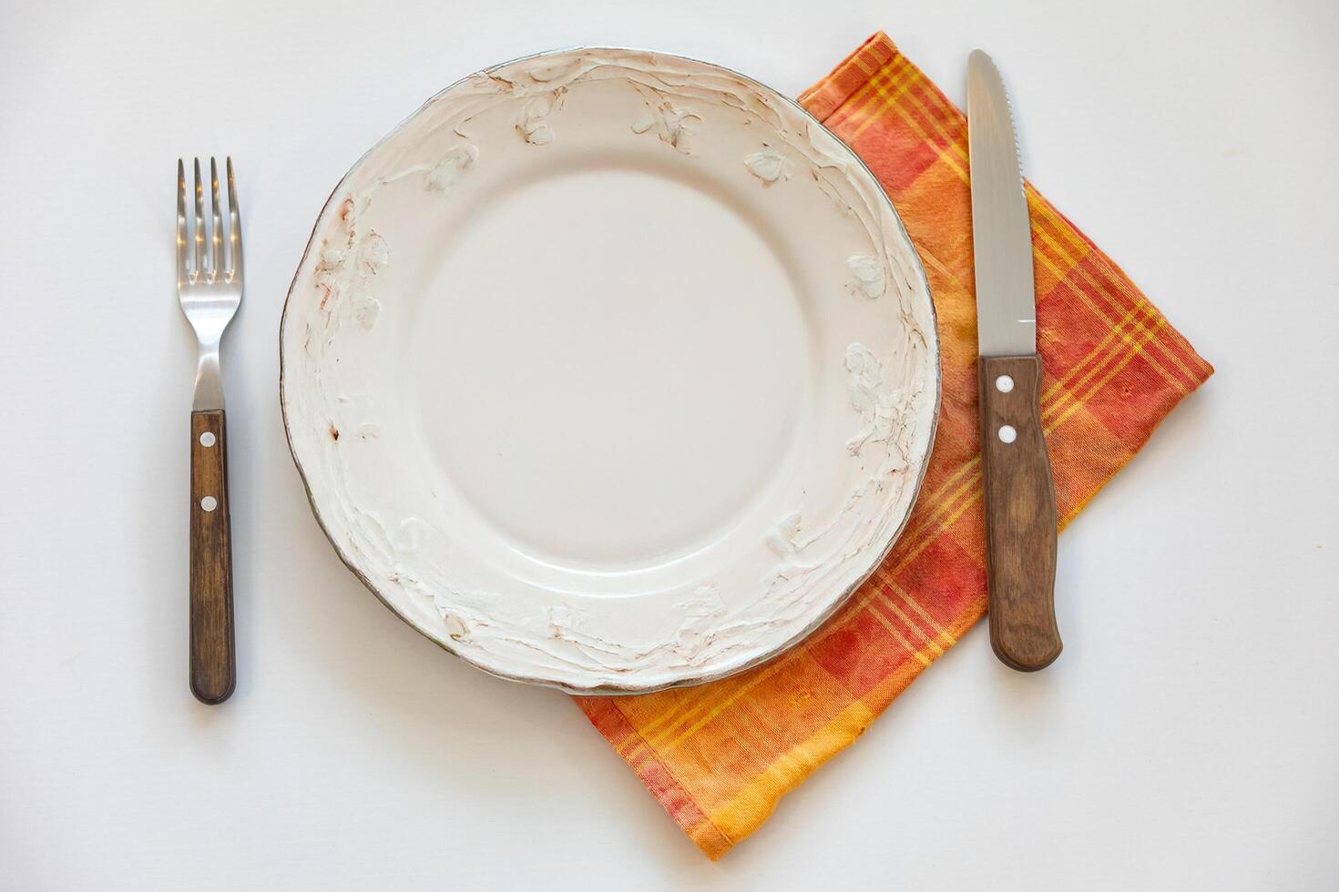 Empty plate top view with metal cutlery next to it photo