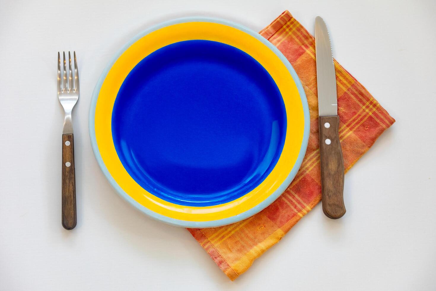 Empty plate top view with metal cutlery next to it photo